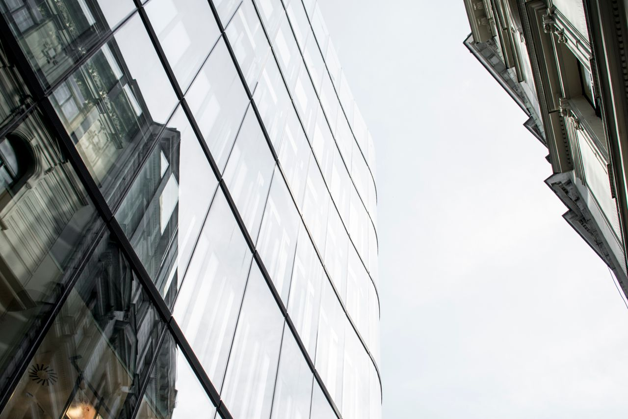 Low angle view of modern glass buildings reflecting the cityscape in Prague.