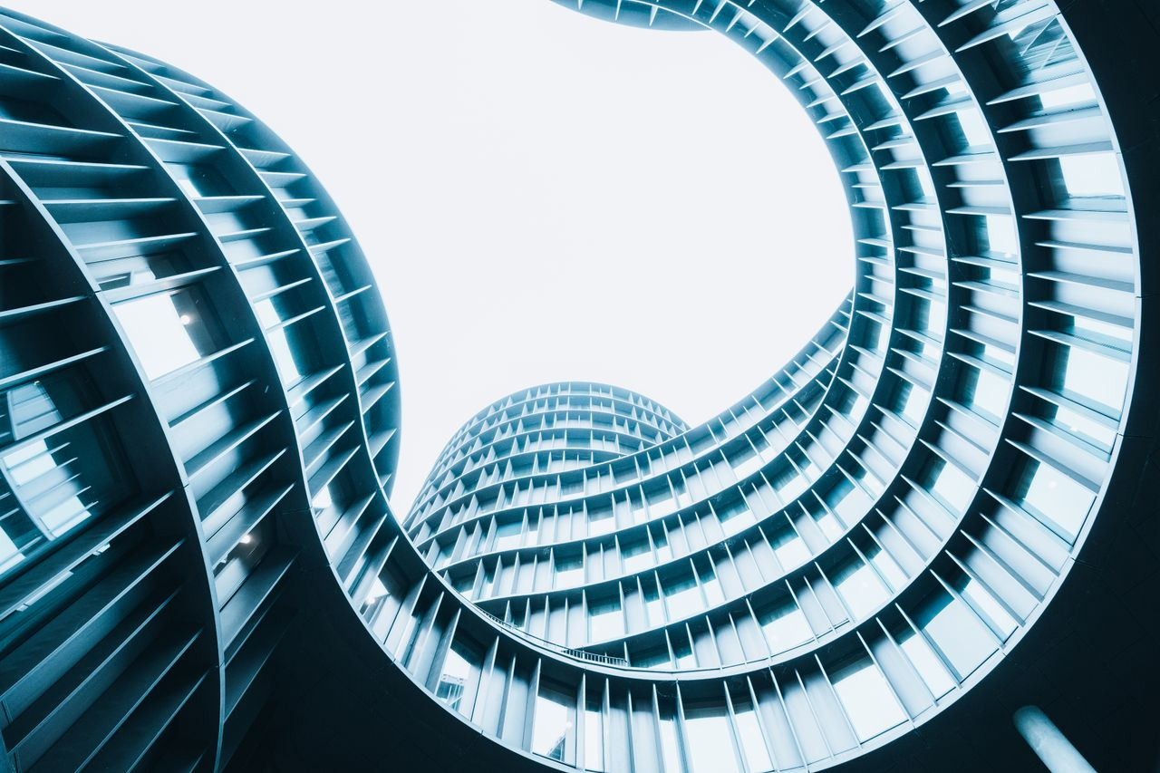 A striking low-angle shot of a modern spiral designed building showcasing urban architectural innovation.
