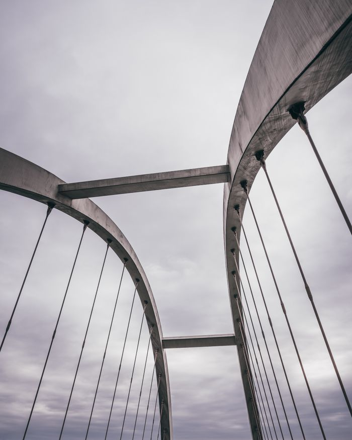 Crafting Captivating Headlines: Your awesome post title goes here A detailed view of a modern suspension bridge set against a cloudy sky.